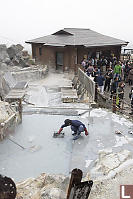 Worker Pulling Black Eggs Out Of Hot Spring