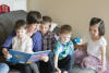 Grandma Reading To Four Kids