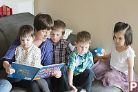 Grandma Reading To Four Kids