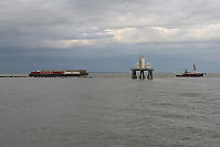 Sandheads Lighhouse With Barge And Tugboat