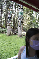 Two Totem Poles In Background