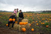 Sitting On Hay Bales In Pumpkin Patch