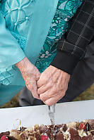 Grandparents Holding Hands To Cut Cake